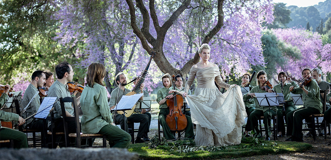 Joyce DiDonato and a chamber ensemble performing outdoors in front of a tree